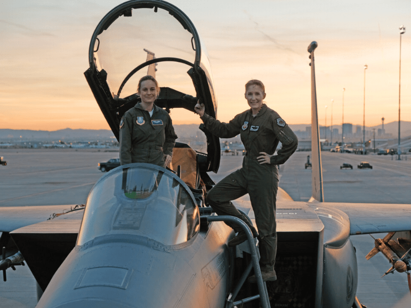 Brie Larson and Brigadier Jeannie Leavitt smiling together in military airplane