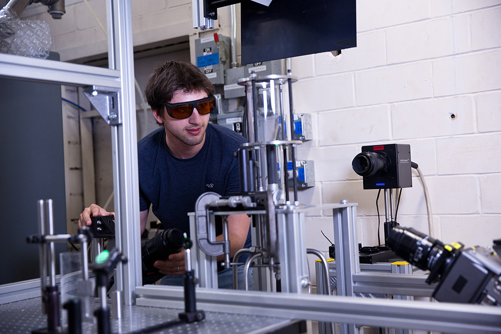 Texas Engineering student wearing safety goggles as he operates complicated machinery